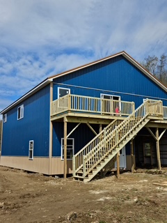 Blue pole barn with deck stairs